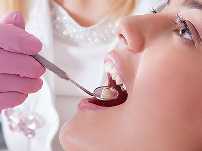 A dental professional is performing a cleaning procedure on a patient s teeth.