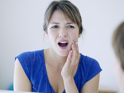 The image shows a woman with her mouth open, looking directly at the camera, with a concerned or worried expression.